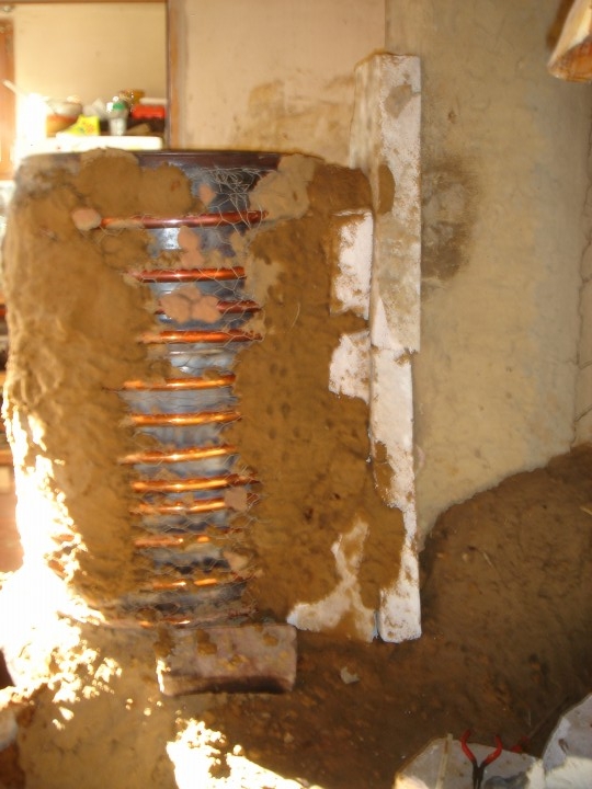 à l'arrière on pose su béton cellulaire pour ne pas dissiper les calories du baril dans la cheminée de la maison
